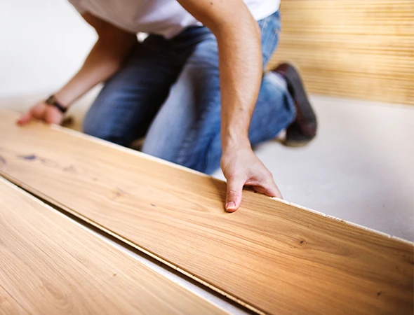 A professional installing hardwood flooring in a Rock Hill SC residence