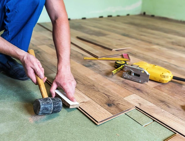 A skilled technician repairing damaged flooring in a Fort Mill SC home