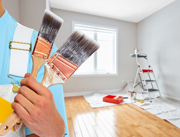 A person displaying two paint brushes for painting work in Rock Hill SC